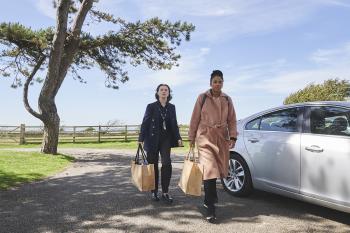 Twee vrouwen naast een auto buiten