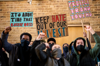 Een groep mensen met gezichtsbedekking voert protest met borden