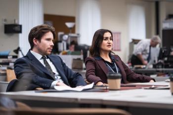 Twee mensen in zakelijke kleding in een rechtszaal.