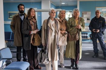 Groep mensen in een wachtkamer, gevarieerd gekleed, uitdrukkingen van bezorgdheid.