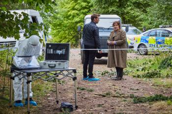 Forensisch onderzoek op misdaadlocatie in bosrijke omgeving.