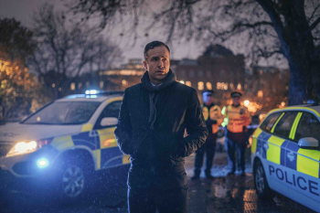 Man in de schemering tussen de politieauto's 