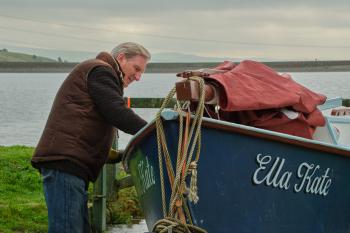 Oude man staat naast boot genaamd Ella Kate