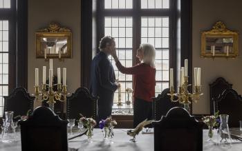 Oude vrouw staat met een jonge man in een landhuis