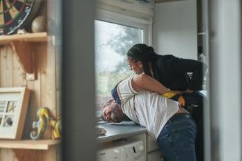 Een vrouw houdt een man in de houdgreep