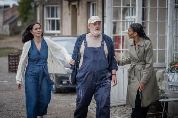 Twee vrouwen lopen bezorgd naast een man
