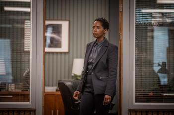 Een vrouw staat bedachtzaam in een deuropening