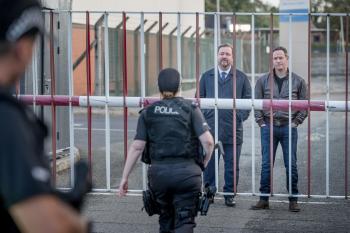 Politieagent loopt naar twee toeschouwers toe