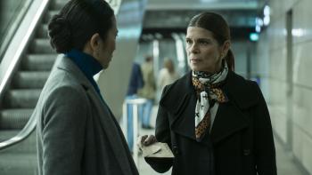 Een vrouw overhandigt een brief aan een andere vrouw