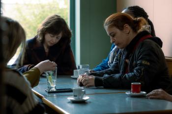 Een aantal vrouwen zitten verdrietig aan tafel 