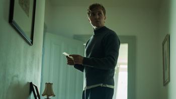 Een man bekijkt iets geheimzinnings in een woonkamer