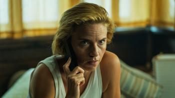 Blonde vrouw in een wit hemd kijkt aandachtig