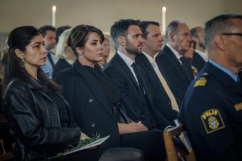 Mensen in pak zitten bij een begrafenis