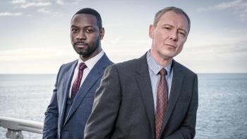 Twee mannen staan voor de zee