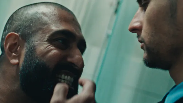 Gevangene laat zijn tanden zien aan een cipier