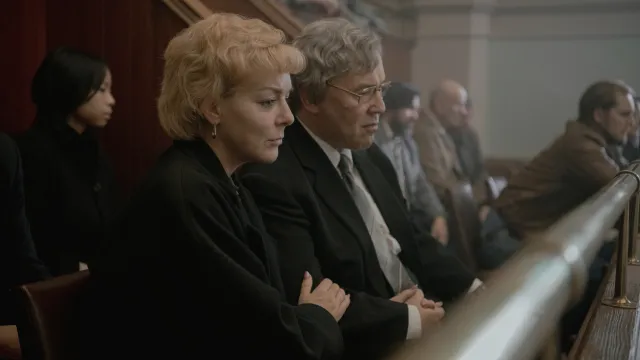 Mensen in een rechtszaal, aandachtig luisterend.