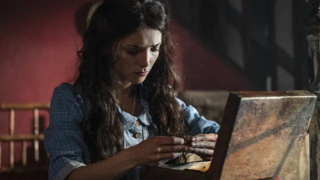 Vrouw kijkt bedachtzaam in kistje