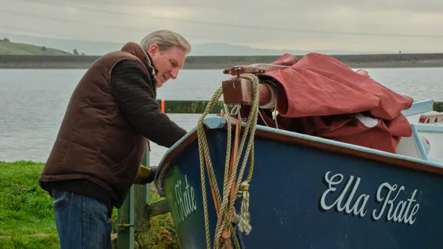 Oude man staat naast boot genaamd Ella Kate