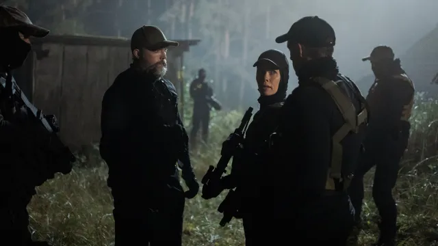 Mensen met geweren in het bos 