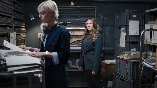 Twee vrouwen staan in een mysterieuze kamer en onderzoeken iets
