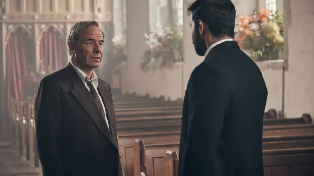 Twee mannen in pak voeren een gesprek in een kerk