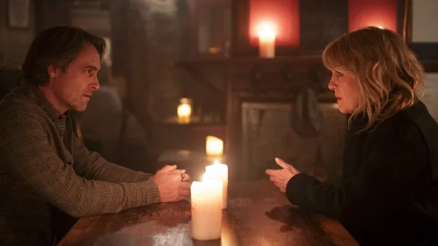 Een man en vrouw voeren een serieus gesprek in kaarslicht