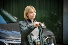 Brigadier Karen Pirie, gespeeld door Lauren Lyle, houd een politie badge omhoog. 