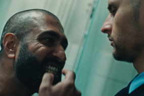 Gevangene laat zijn tanden zien aan een cipier