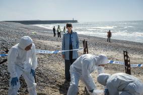 Forensisch team werkt op een kiezelstrand.