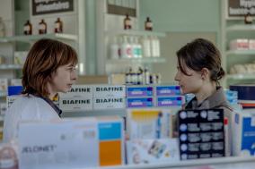 Twee vrouwen praten met elkaar in een apotheek 