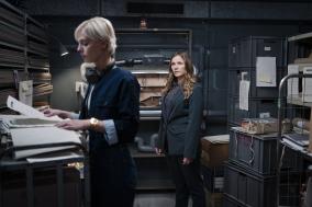 Twee vrouwen staan in een mysterieuze kamer en onderzoeken iets