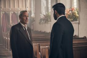 Twee mannen in pak voeren een gesprek in een kerk