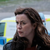 Actrice Eve Myles speelt Jeanette in The Crow Girl en kijkt bezirgd langs de camera met wind in haar haar
