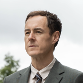 Man met bruin haar in grijs pak