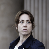 Vrouw met blauwe jas, weg kijkend van de camera