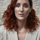 Serieus kijkende vrouw met rode krullen